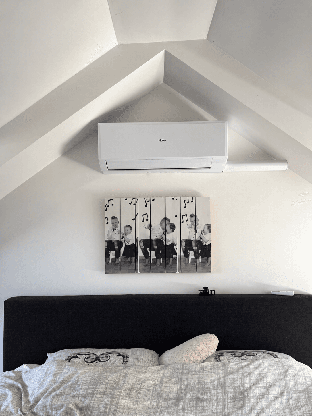 Airco-binnendeel onder een schuine kap in een slaapkamer
